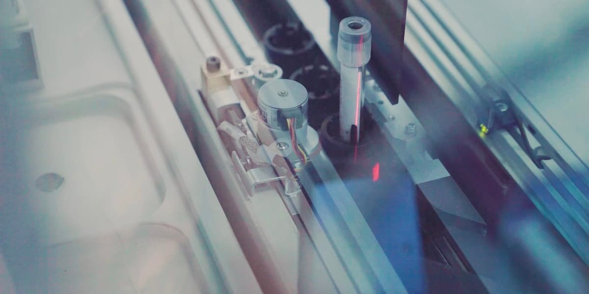 Clinical laboratory instrumentation, shown close up and out of focus.